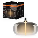 Osram Vintage 1906 Big Elipse ist eine dimmbare LED-Lampe mit Filament in Ellipsenform. Sie bietet 4 W für 60 lm, E27 Fassung, Smoke Design, 215 mm Durchmesser, Farbwiedergabe CRI 80, 1800 K.