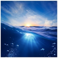 Wallario Möbelfolie Wellen im Meer bei Sonnenuntergang blau|schwarz