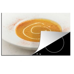 MuchoWow Herdblende-/Abdeckplatte Kürbissuppe im weißen Teller mit Cayennepfeffer bestreut, Vinyl, (1 tlg), 91×52 cm, Induktionskochfeld Schutz für die küche, Ceranfeldabdeckung bunt